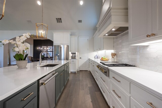 kitchen featuring premium range hood, light countertops, a chandelier, a sink, and appliances with stainless steel finishes