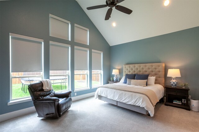 bedroom featuring carpet floors, multiple windows, baseboards, and high vaulted ceiling