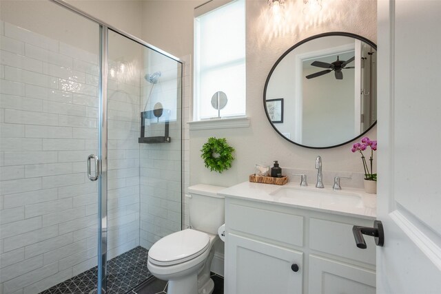 full bathroom with vanity, a ceiling fan, toilet, and a shower stall