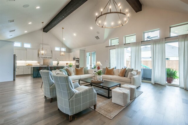 living area featuring an inviting chandelier, light wood-style floors, high vaulted ceiling, beamed ceiling, and visible vents