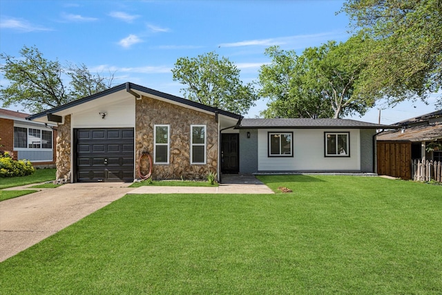 view of front of property featuring an attached garage, stone siding, a front yard, and concrete driveway