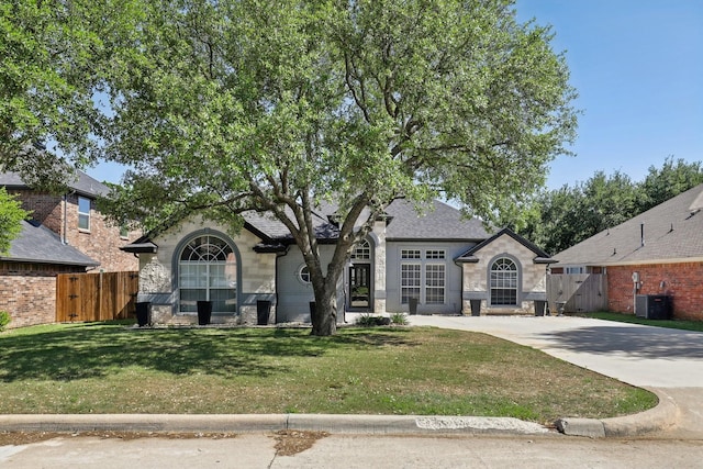 view of front of property with a gate, central air condition unit, a front lawn, and fence