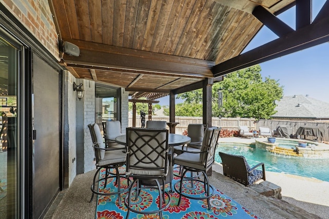 view of patio / terrace featuring outdoor dining space, a fenced backyard, and a pool with connected hot tub
