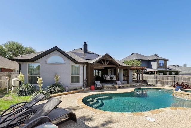 view of swimming pool featuring a fenced backyard, a pool with connected hot tub, and a patio