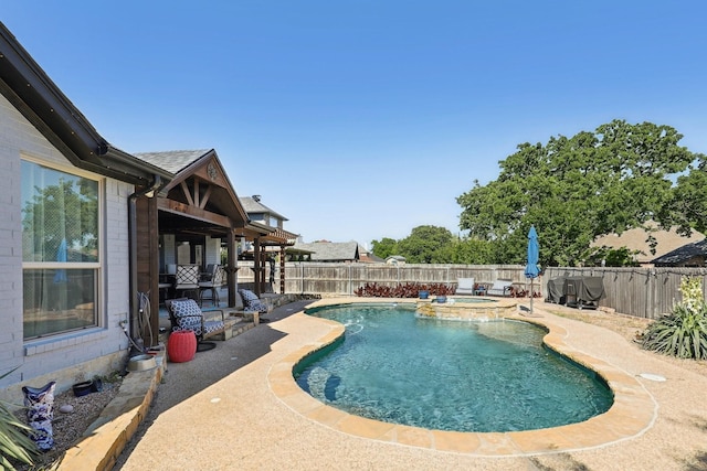 view of swimming pool with a fenced backyard, a pool with connected hot tub, and a patio area