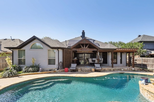 rear view of property featuring a fenced in pool, a patio area, solar panels, fence, and brick siding