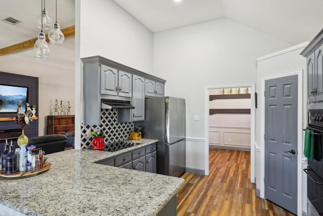 kitchen with visible vents, gray cabinets, freestanding refrigerator, and under cabinet range hood