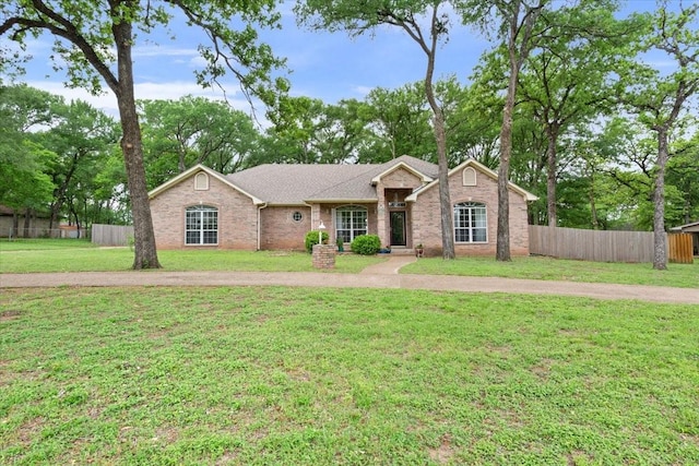 single story home with brick siding, a front lawn, and fence
