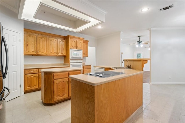 kitchen with visible vents, white appliances, a sink, and a center island with sink