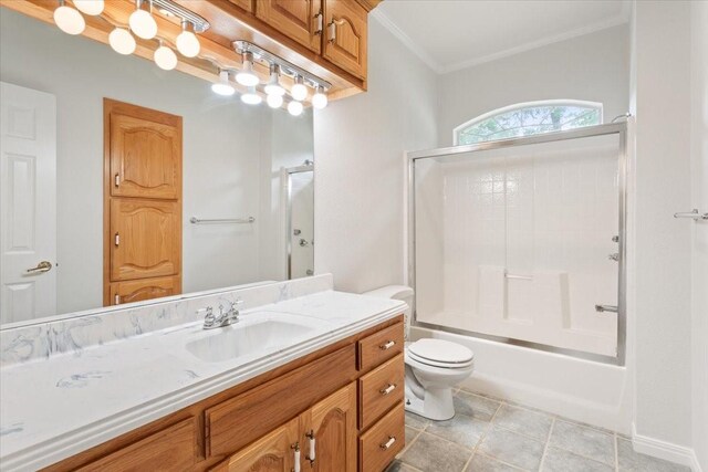 bathroom with bath / shower combo with glass door, toilet, vanity, and ornamental molding