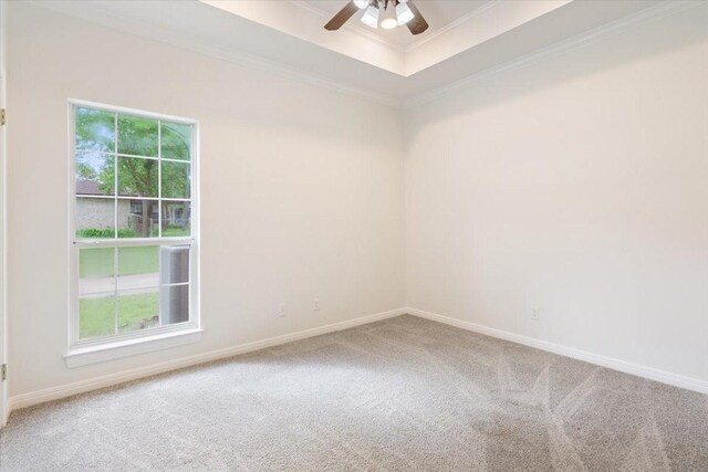 empty room featuring crown molding, a healthy amount of sunlight, carpet flooring, and a ceiling fan