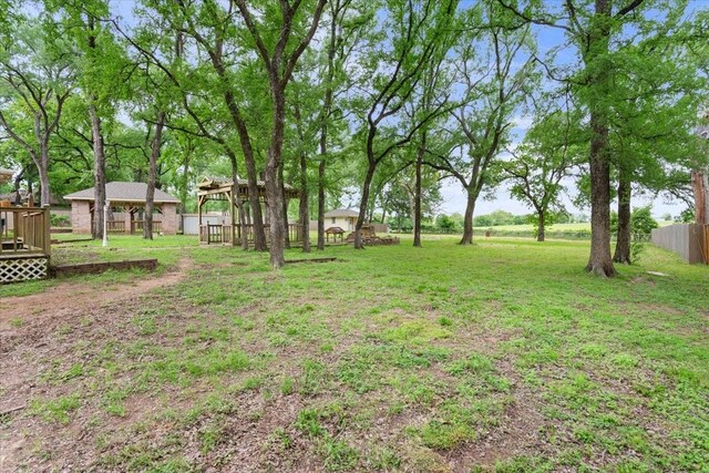 view of yard with a wooden deck and fence