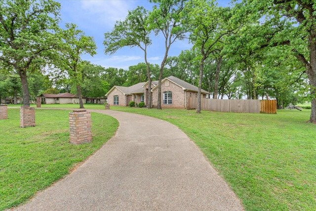 view of front of house with fence, a front lawn, and brick siding