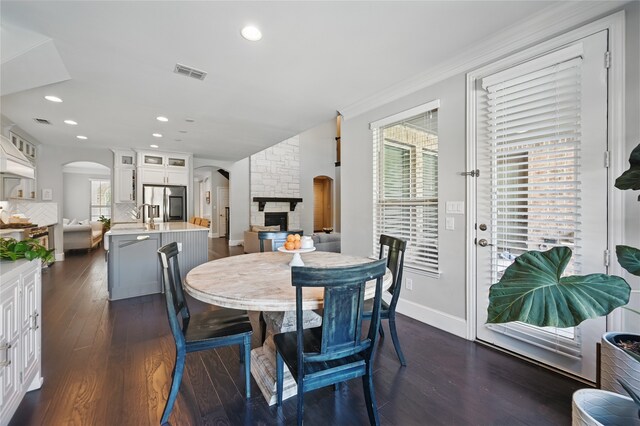 dining room with visible vents, arched walkways, dark wood-style floors, and recessed lighting