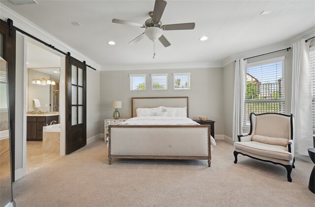 bedroom featuring baseboards, ornamental molding, a barn door, and light colored carpet