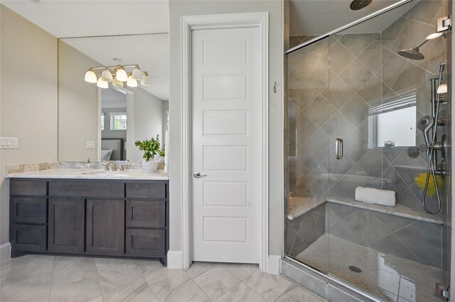 ensuite bathroom with vanity, marble finish floor, ensuite bathroom, baseboards, and a shower stall
