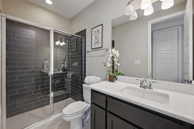 full bath featuring toilet, a shower stall, and vanity