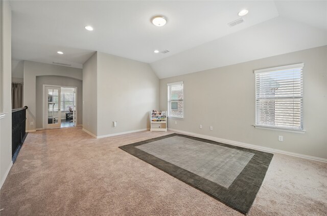 spare room featuring baseboards, recessed lighting, lofted ceiling, and light carpet