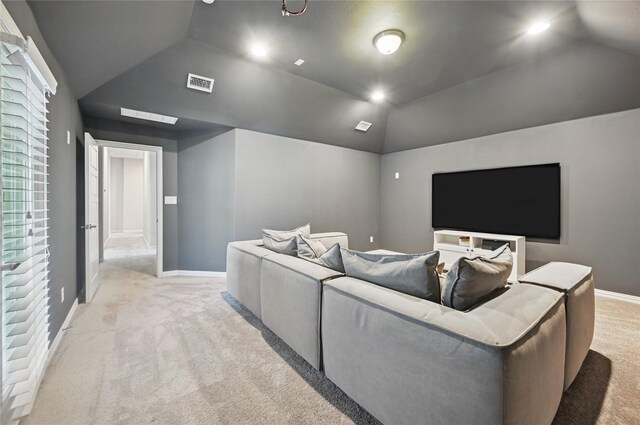 cinema room with light colored carpet, baseboards, lofted ceiling, and visible vents