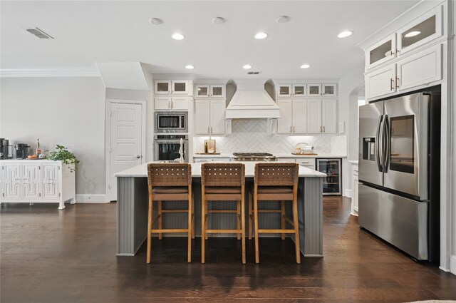 kitchen featuring decorative backsplash, visible vents, premium range hood, wine cooler, and stainless steel appliances