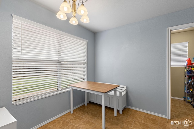unfurnished office with a chandelier, tile patterned floors, and baseboards