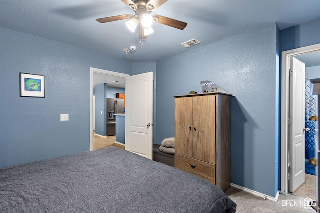 bedroom featuring light colored carpet, a textured wall, and visible vents