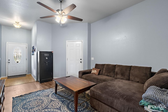 living room featuring light wood-type flooring, a ceiling fan, and baseboards