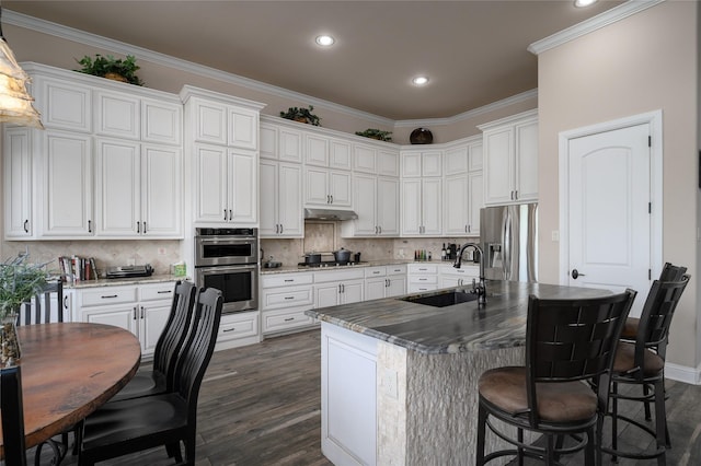 8636 Morgan Rd, Blue Ridge, TX 75424 - kitchen with stainless steel appliances, a sink, dark wood-style floors, ornamental molding, and a breakfast bar area