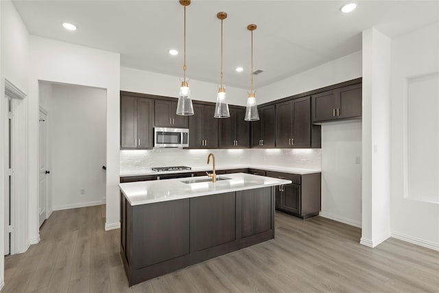 917 Janwood Dr, Plano, TX 75075 - kitchen featuring appliances with stainless steel finishes, a sink, dark brown cabinets, light wood-style floors, and recessed lighting
