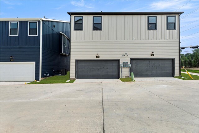 917 Janwood Dr, Plano, TX 75075 - view of front facade featuring an attached garage, concrete driveway, cooling unit, and board and batten siding