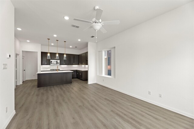 917 Janwood Dr, Plano, TX 75075 - kitchen with stainless steel microwave, open floor plan, dark brown cabinets, light countertops, and recessed lighting