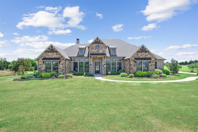 craftsman-style house featuring a chimney, stone siding, and a front yard