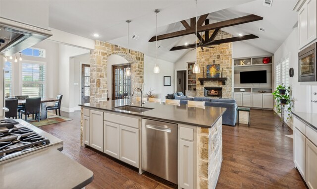 kitchen featuring a ceiling fan, appliances with stainless steel finishes, a sink, and dark countertops