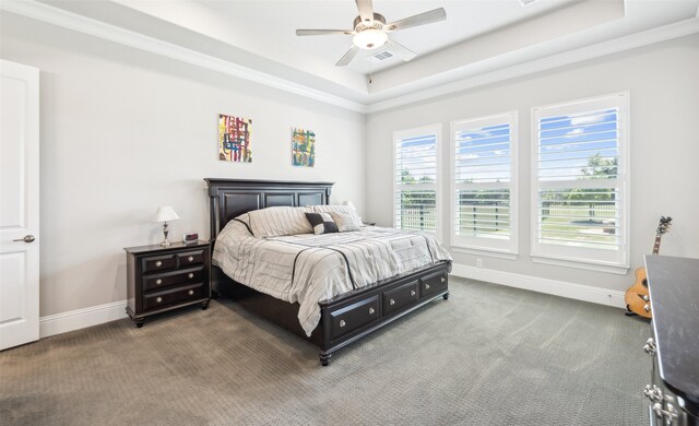 carpeted bedroom featuring a raised ceiling, visible vents, crown molding, baseboards, and ceiling fan