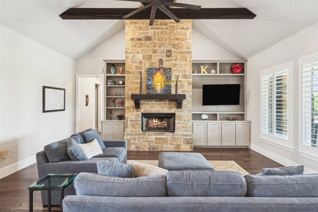 living area with a ceiling fan, a stone fireplace, beamed ceiling, baseboards, and dark wood-style floors