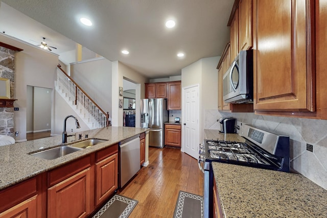 4001 Dellman Dr, Fort Worth, TX 76262 - kitchen featuring light wood finished floors, light stone counters, stainless steel appliances, a sink, and ceiling fan