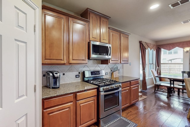 4001 Dellman Dr, Fort Worth, TX 76262 - kitchen with brown cabinets, visible vents, and stainless steel appliances