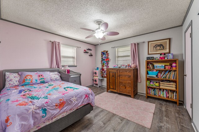 bedroom with a ceiling fan, wood finished floors, a textured ceiling, and multiple windows