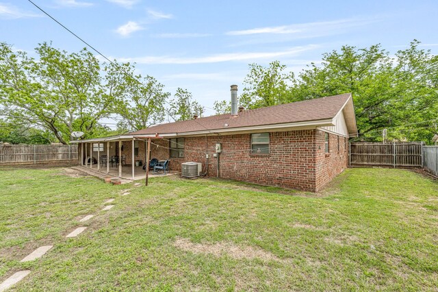 back of house featuring a fenced backyard, a yard, and a patio area