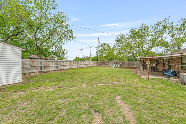view of yard featuring a patio area, a fenced backyard, and a playground
