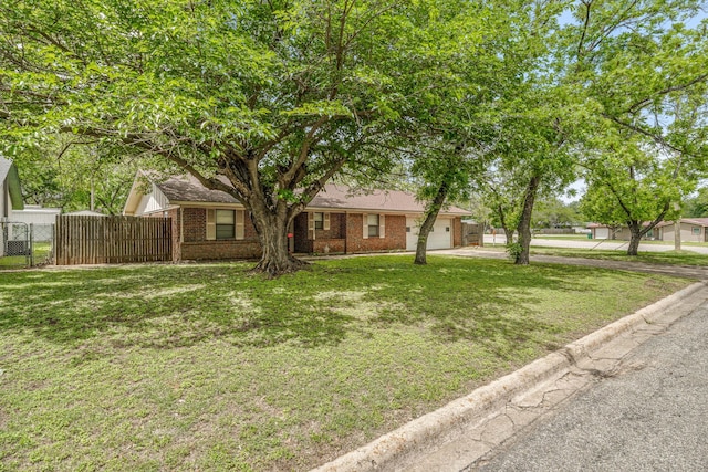 view of front of property featuring a front lawn, brick siding, fence, and a garage