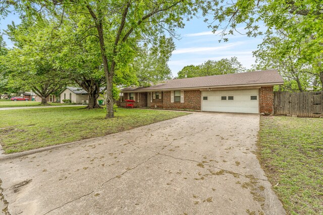single story home featuring fence, brick siding, a garage, and concrete driveway