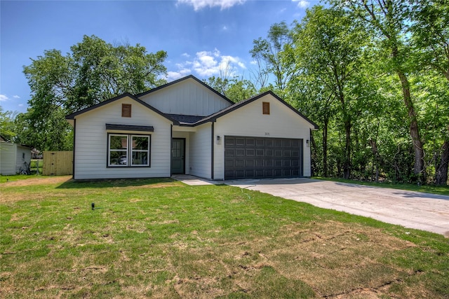 ranch-style house featuring an attached garage, driveway, board and batten siding, and a front yard