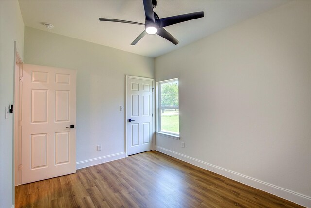 unfurnished bedroom featuring wood finished floors, a ceiling fan, and baseboards