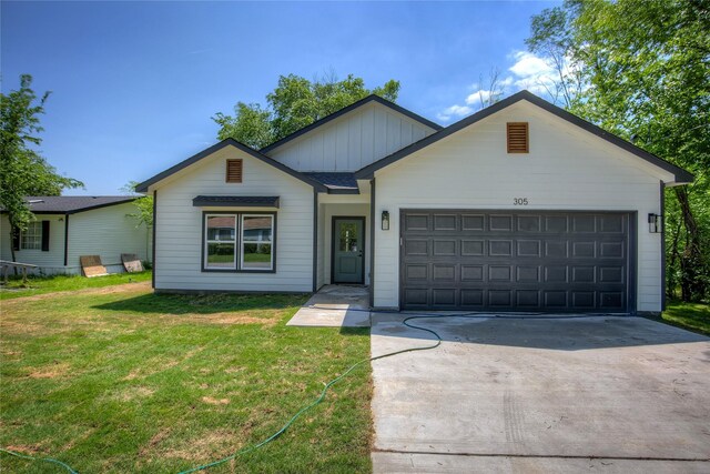 ranch-style home with a garage, driveway, board and batten siding, and a front yard