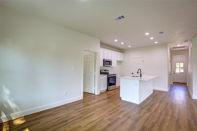 kitchen featuring wood finished floors, stainless steel appliances, visible vents, and a sink