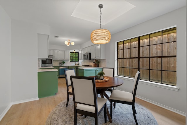 dining space with visible vents, light wood finished floors, and baseboards