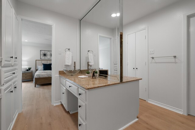 ensuite bathroom with vanity, recessed lighting, wood finished floors, and ensuite bath