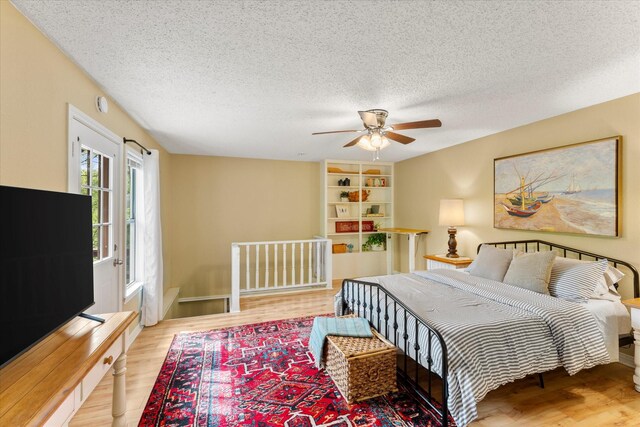 bedroom featuring wood finished floors, a textured ceiling, and ceiling fan