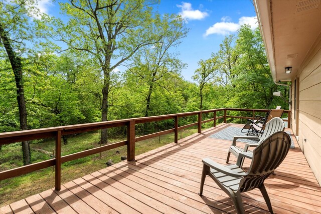 wooden terrace featuring a view of trees